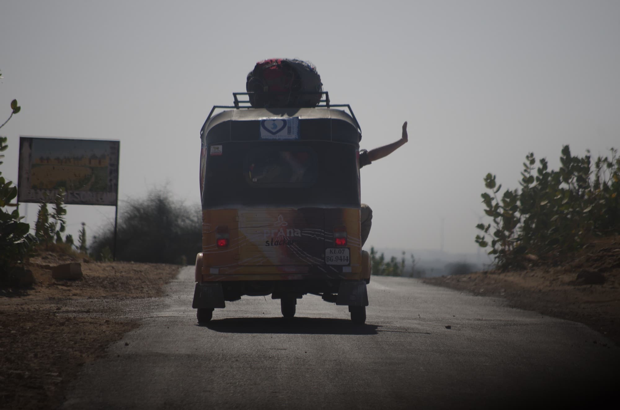 Waving out of a rickshaw